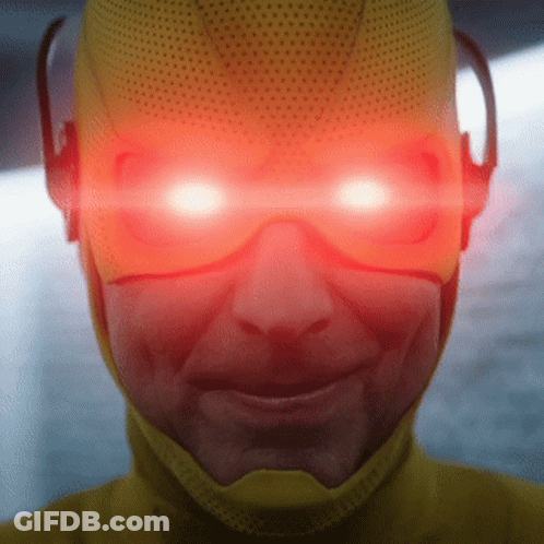 A Close Up Of A Person Wearing A Yellow Superhero Costume With Red Eyes GIF