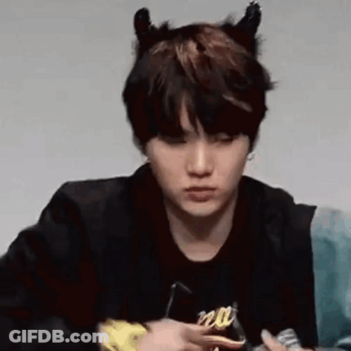 A Close Up Of A Person Wearing Devil Horns And A Black Jacket . GIF
