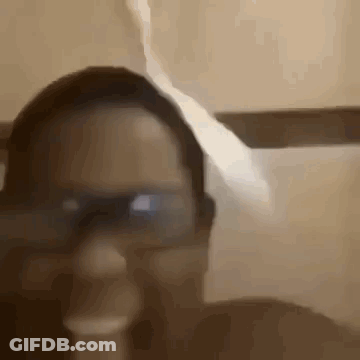 A Close Up Of A Person Wearing Glasses And A Hat In A Bathroom . GIF