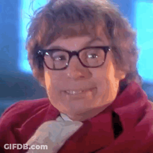 A Close Up Of A Person Wearing Glasses And A Red Coat GIF