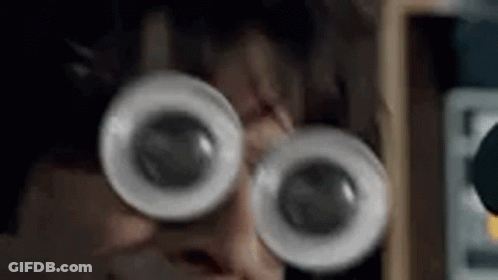 A Close Up Of A Person Wearing Glasses With Big Eyes . GIF