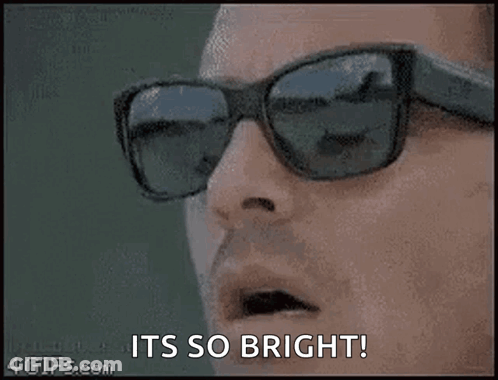 A Close Up Of A Person Wearing Sunglasses With The Words `` It 'S So Bright '' . GIF