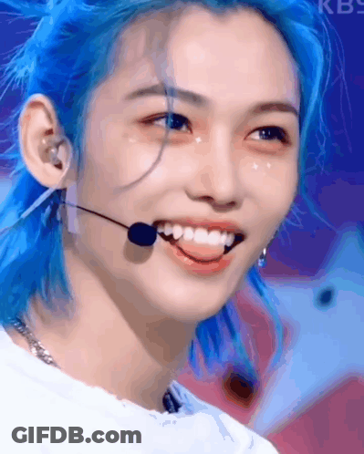 A Close Up Of A Person With Blue Hair And A Microphone . GIF