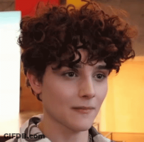 A Close Up Of A Person With Curly Hair Making A Face . GIF