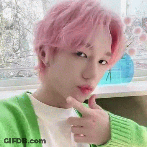 A Close Up Of A Person With Pink Hair Wearing A Green Sweater . GIF