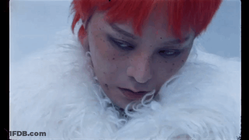 A Close Up Of A Person With Red Hair And Freckles Wearing A White Fur Coat . GIF