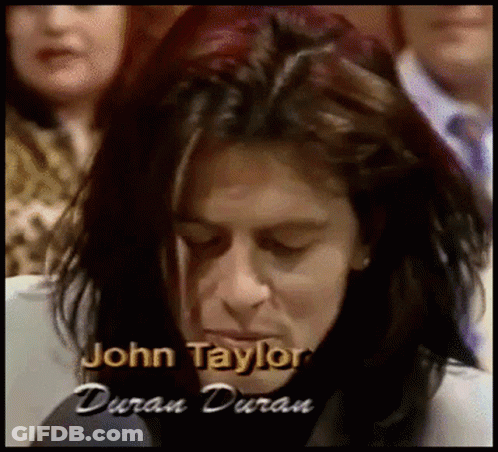 A Close Up Of A Person With The Name John Taylor Written On The Bottom GIF