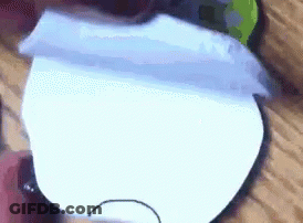 A Close Up Of A Piece Of Paper With A Hole In It . GIF