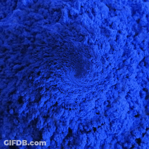 A Close Up Of A Pile Of Blue Powder With A Swirl In The Middle GIF