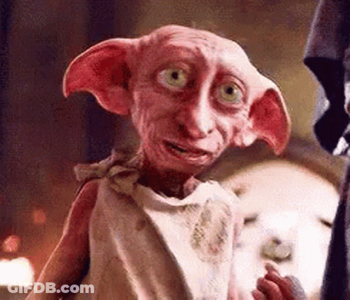 A Close Up Of A Pink Dobby From Harry Potter Standing Next To A Person . GIF