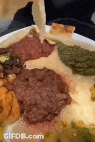 A Close Up Of A Plate Of Food With Meat And Vegetables On It GIF