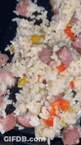 A Close Up Of A Plate Of Food With Rice , Sausage , And Peppers . GIF