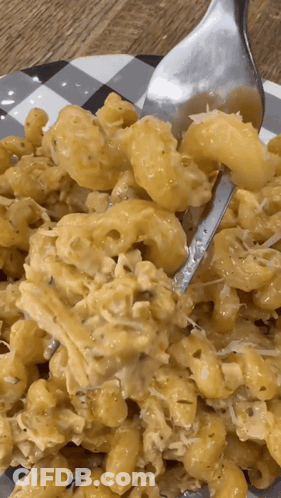 A Close Up Of A Plate Of Macaroni And Cheese With A Fork GIF