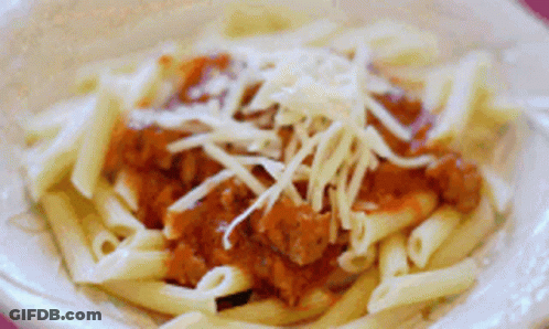 A Close Up Of A Plate Of Pasta With Meat Sauce And Cheese GIF