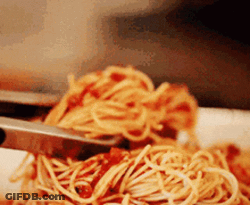 A Close Up Of A Plate Of Spaghetti With Sauce GIF
