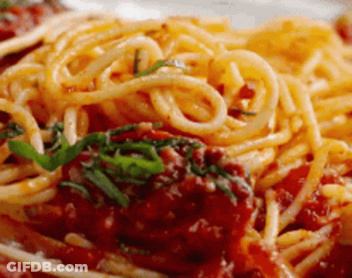 A Close Up Of A Plate Of Spaghetti With Tomato Sauce And Meatballs . GIF