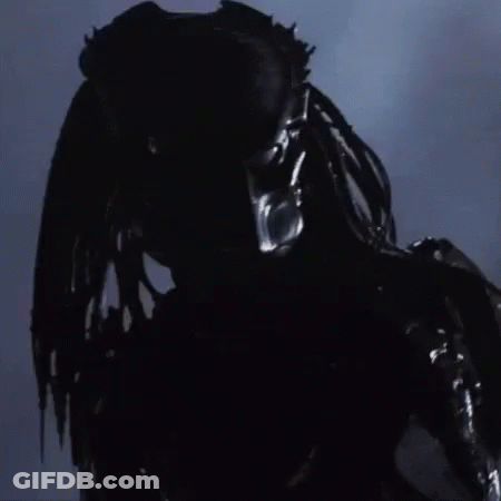 A Close Up Of A Predator 'S Face With A Blurred Background GIF