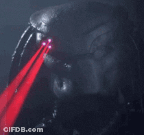 A Close Up Of A Predator 'S Face With Red Lasers Coming Out Of His Eyes GIF
