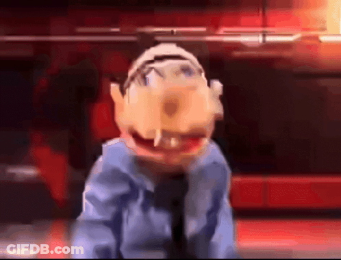 A Close Up Of A Puppet In A Blue Shirt And Tie Making A Funny Face GIF