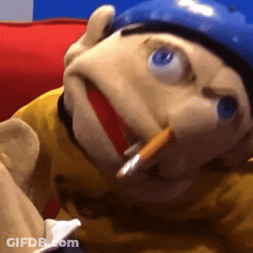 A Close Up Of A Puppet Wearing A Yellow Shirt And A Blue Helmet With A Cigarette In His Mouth GIF