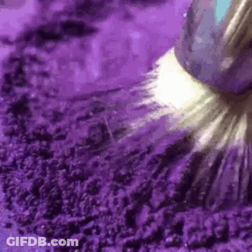 A Close Up Of A Purple Powder With A Brush . GIF