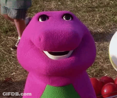 A Close Up Of A Purple Stuffed Animal With A Green Triangle On His Chest . GIF