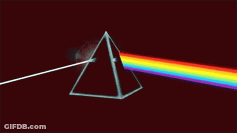 A Close Up Of A Rainbow Colored Light On A Black Background GIF