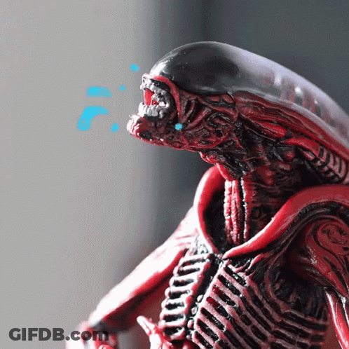 A Close Up Of A Red Alien Figurine With Blue Bubbles Coming Out Of It 'S Mouth GIF