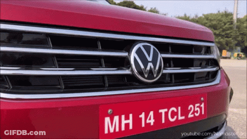 A Close Up Of A Red Volkswagen With A License Plate That Says Mh 14 Tcl 251 GIF