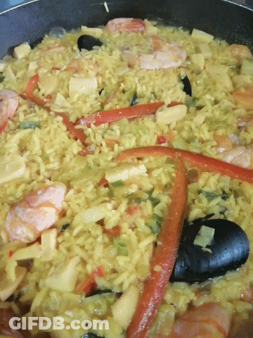 A Close Up Of A Rice Dish With Vegetables And Seafood GIF