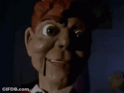 A Close Up Of A Scary Puppet With A Shadow On His Face . GIF