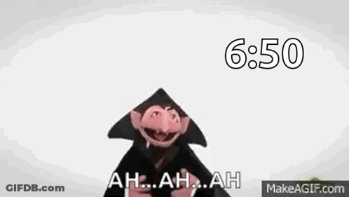 A Close Up Of A Sesame Street Character Wearing A Black Hat And A Black Robe . GIF