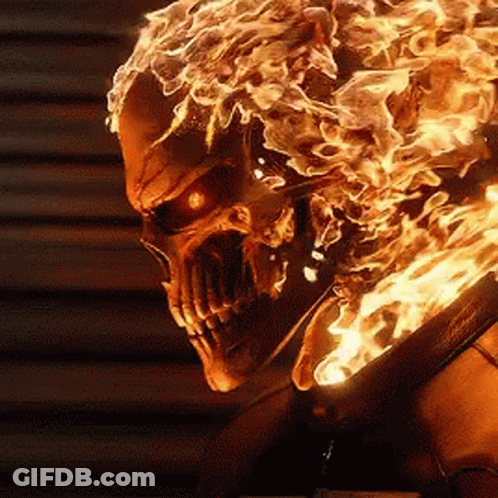 A Close Up Of A Skull With Flames Coming Out Of It 'S Head GIF