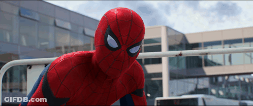 A Close Up Of A Spider Man In Front Of A Large Building GIF