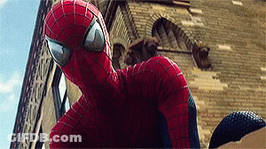 A Close Up Of A Spider Man Standing In Front Of A Building . GIF