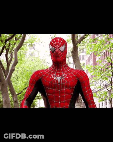 A Close Up Of A Spider Man Standing In Front Of A Building GIF