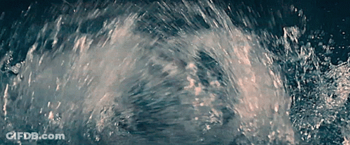A Close Up Of A Splash Of Water In A Dark Room GIF