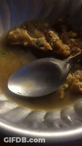 A Close Up Of A Spoon In A Bowl Of Sauce GIF