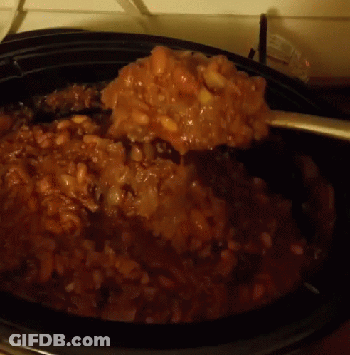 A Close Up Of A Spoon In A Crock Pot Filled With Beans GIF