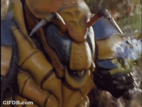 A Close Up Of A Statue Of A Bug With Horns And Sharp Teeth GIF