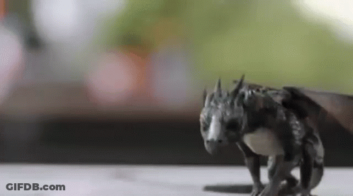 A Close Up Of A Statue Of A Dragon Walking On A Table . GIF