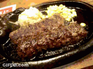 A Close Up Of A Steak On A Sizzling Plate GIF