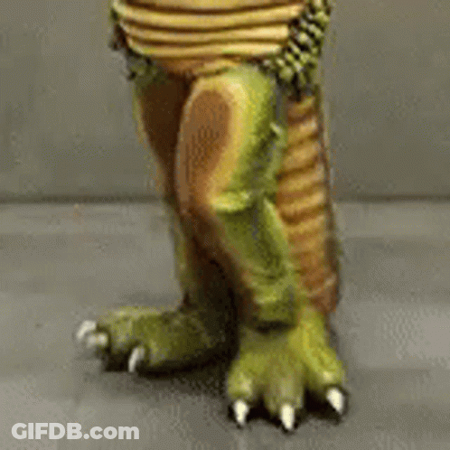 A Close Up Of A Toy Dinosaur 'S Feet And Claws . GIF