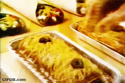 A Close Up Of A Tray Of Food With Cheese And Olives GIF