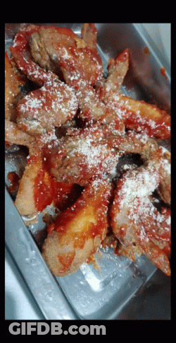 A Close Up Of A Tray Of Food With Sauce And Cheese GIF