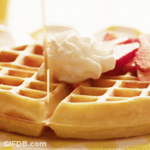 A Close Up Of A Waffle With Whipped Cream And Syrup GIF