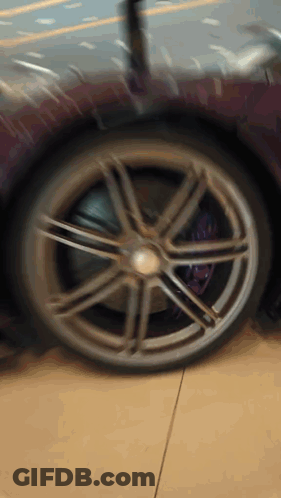 A Close Up Of A Wheel On A Purple Sports Car GIF