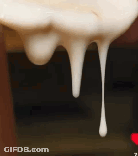 A Close Up Of A White Liquid Dripping From A Bottle GIF