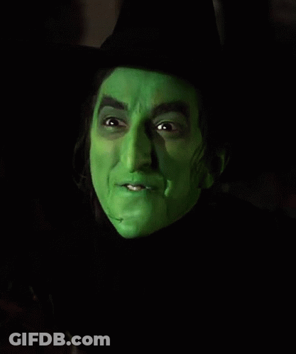 A Close Up Of A Witch 'S Face With Green Paint On It . GIF