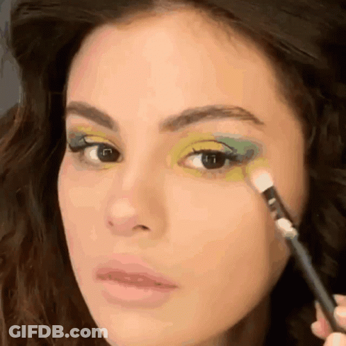 A Close Up Of A Woman Applying Green Eye Shadow GIF